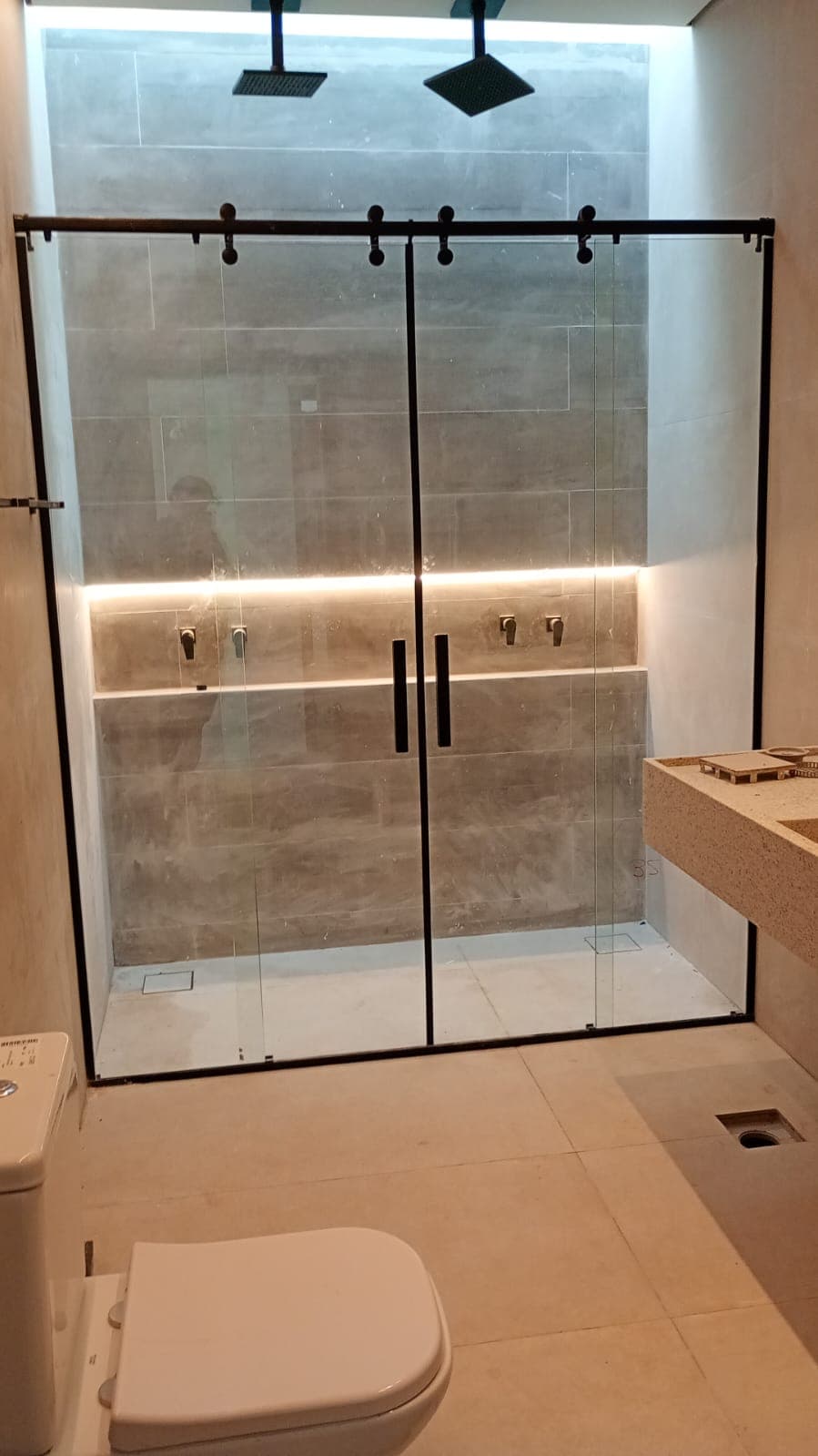 Box de banheiro duplo com trilho preto e duchas duplas