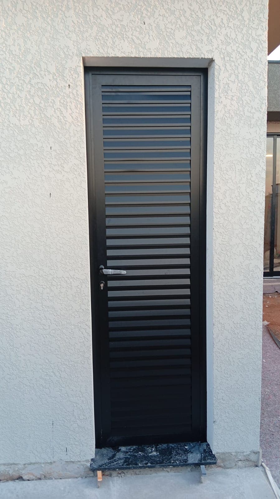 Porta veneziana em alumínio preto de piso a teto
