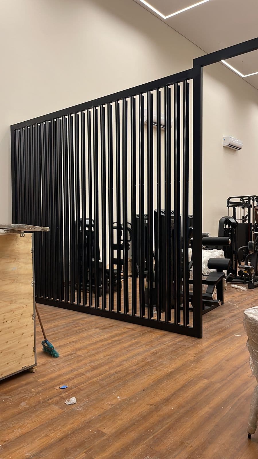 Divisória decorativa em ripas de metal preto em academia