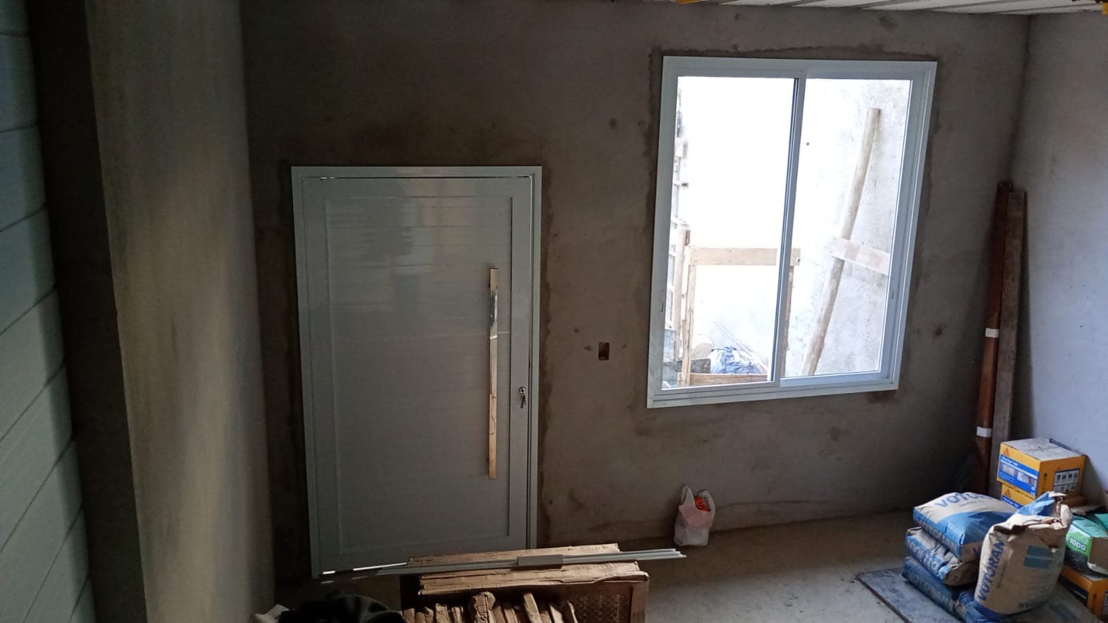 Porta de alumínio e janela de correr branca em obra residencial