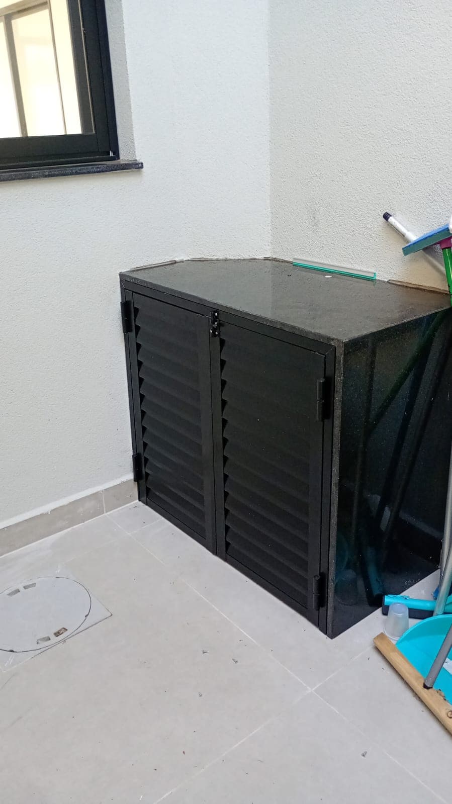 Gabinete de canto em alumínio ripado preto com tampo de granito